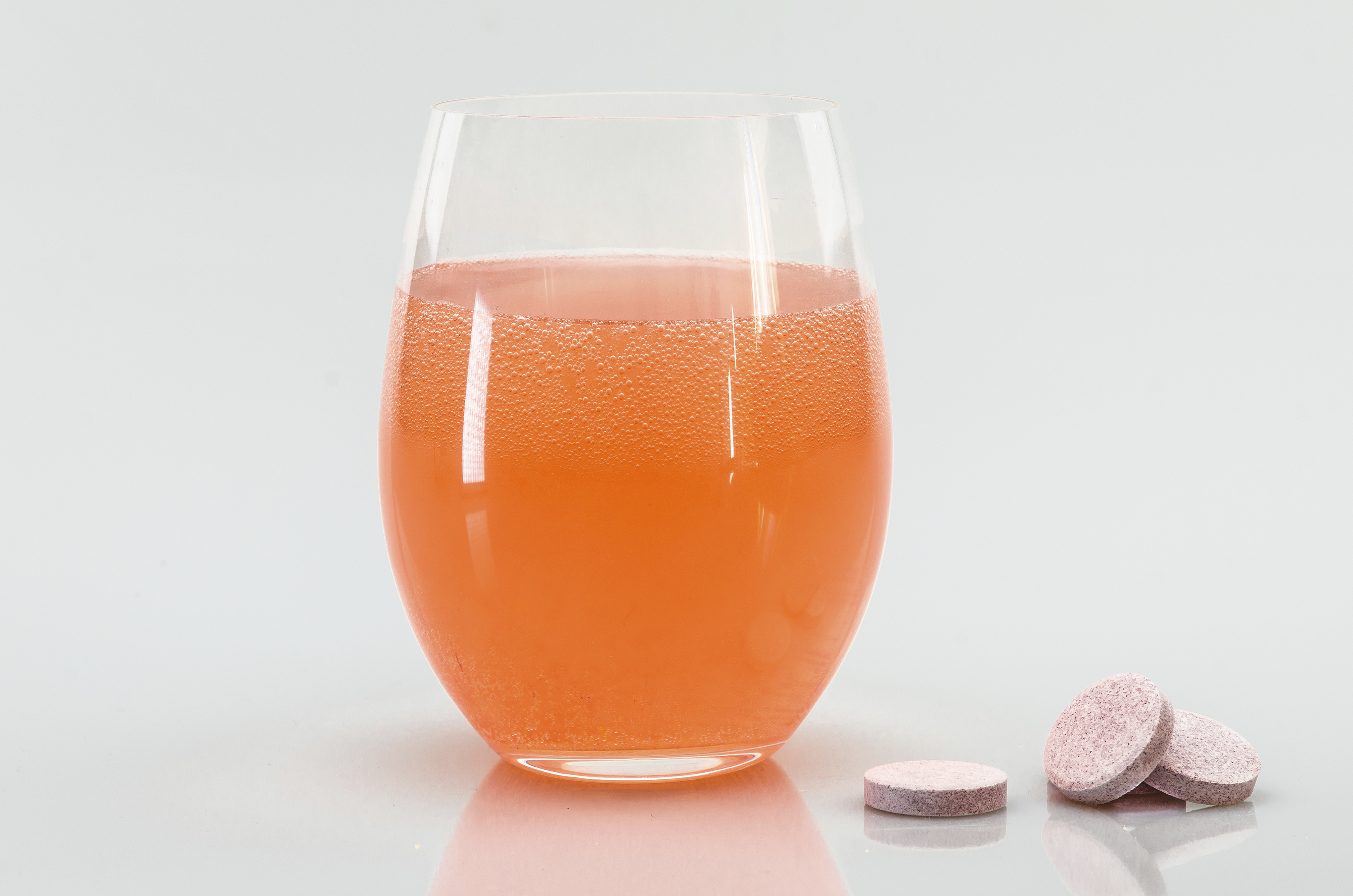 Glass of water with vitamin pills